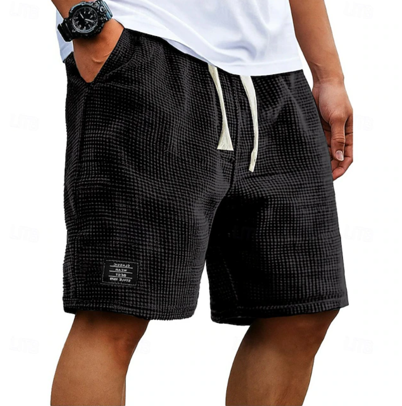 Men's black waffle shorts with relaxed fit, textured fabric, drawstring waist and side pockets