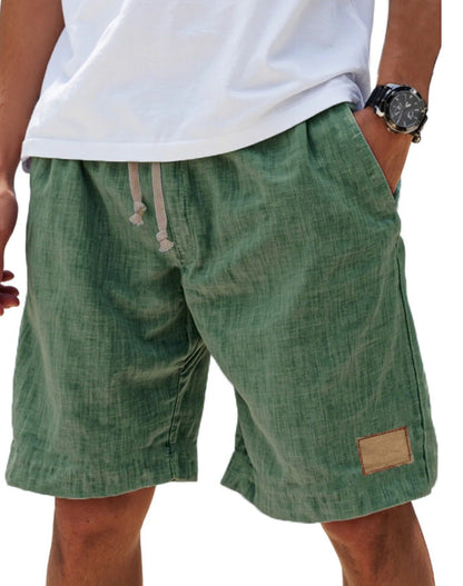 Men's green cotton shorts with relaxed fit, elasticated drawstring waist and side pockets
