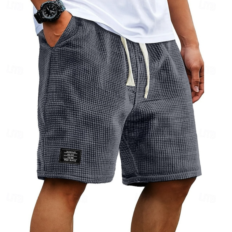 Men's grey waffle shorts with relaxed fit, textured fabric, drawstring waist and side pockets